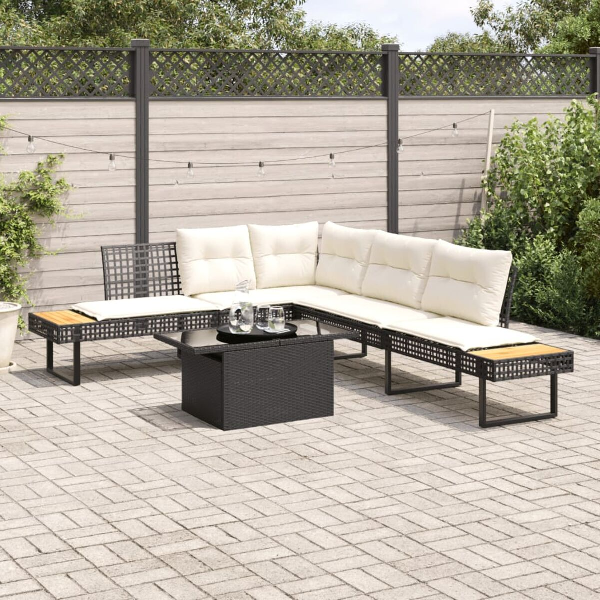 Set divani da esterno con tavolino su un patio. Colori nero e crema.