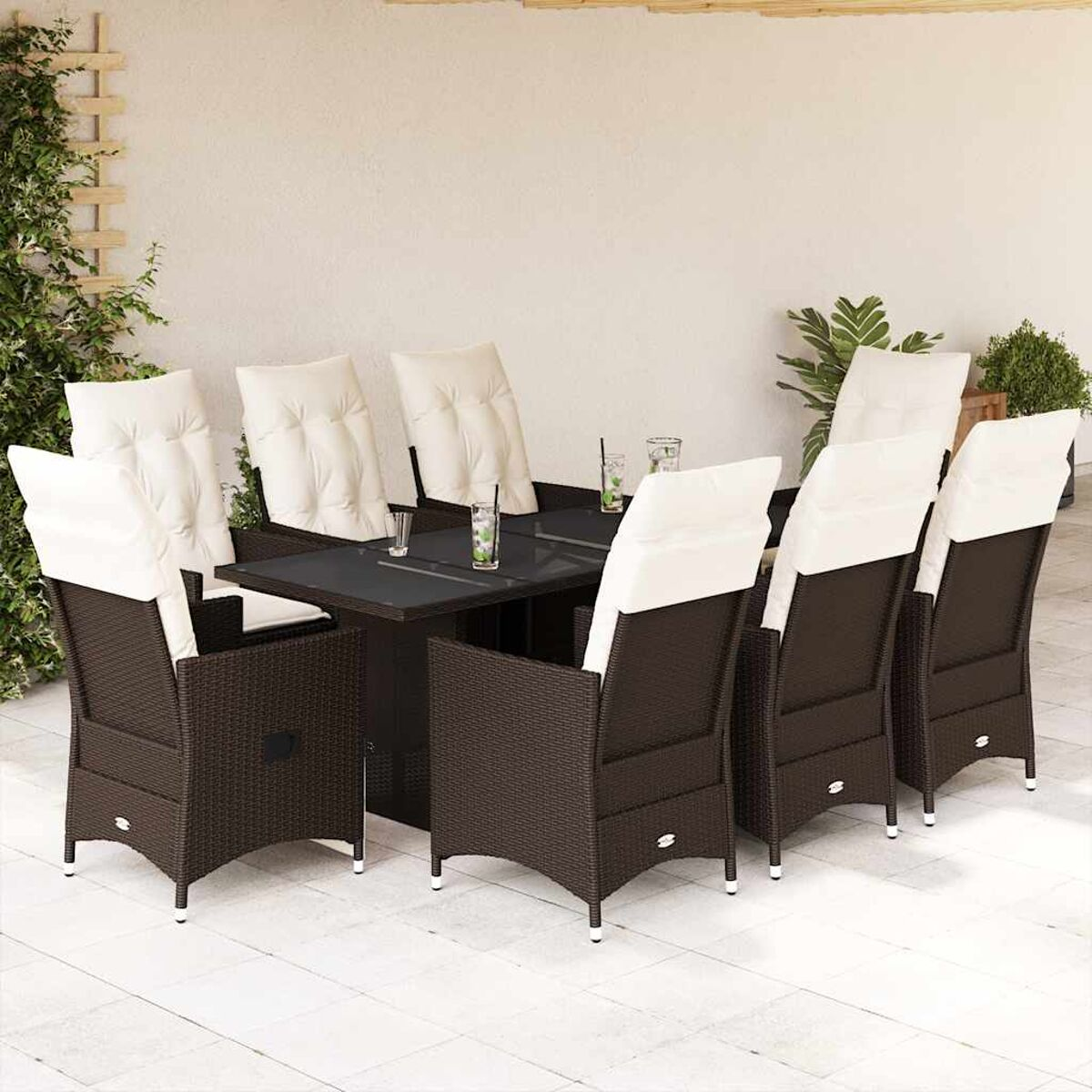 Set da pranzo per esterni con sedie in vimini marrone scuro, piano del tavolo in vetro e cuscini bianchi.
