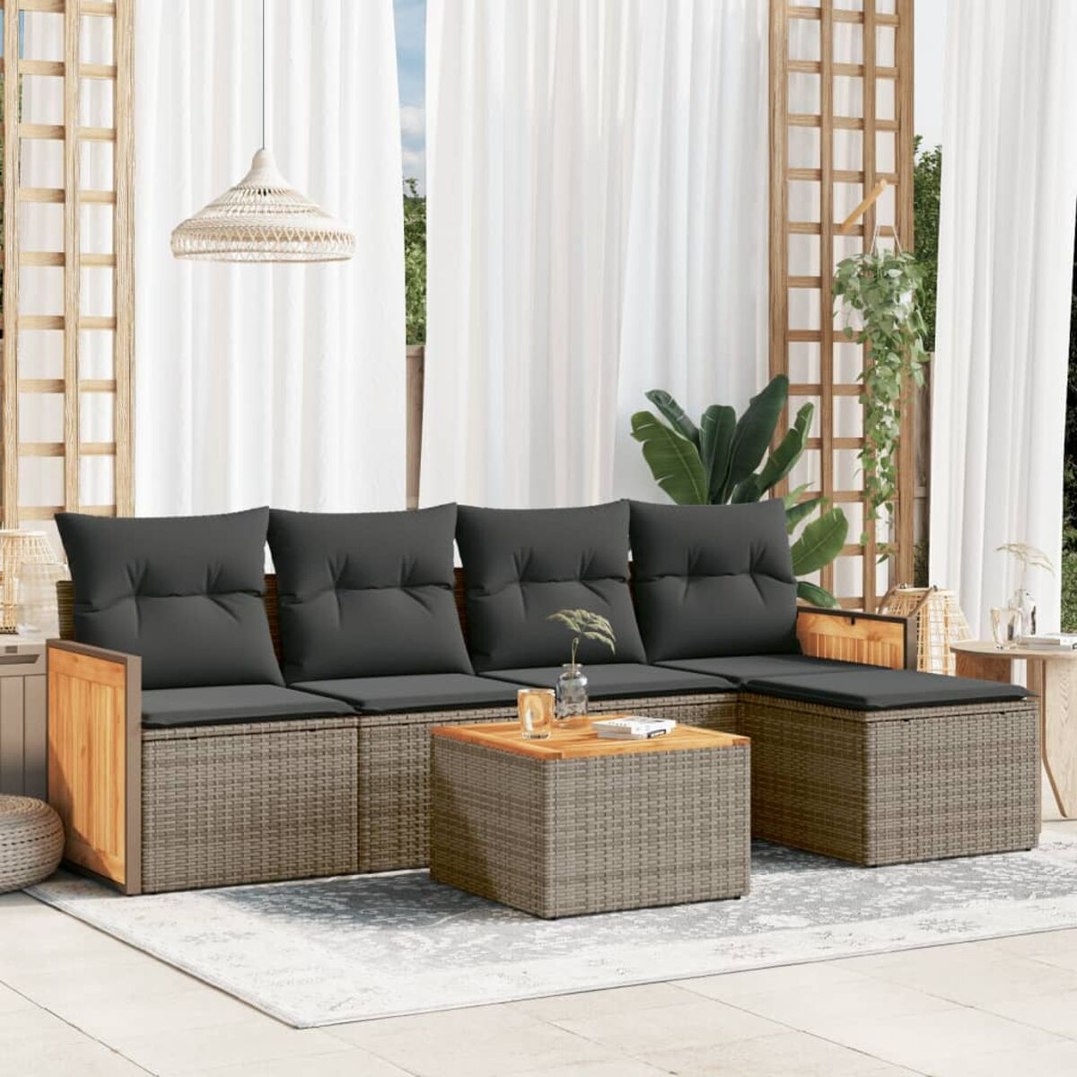 Set di sedute da esterno con cuscini grigi, tavolo in legno e design in vimini.