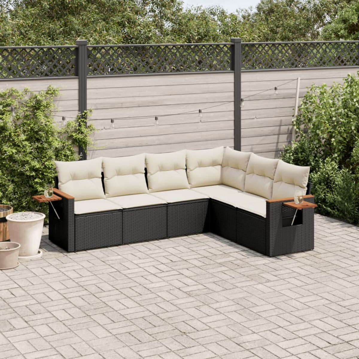 Schwarzes Rattan-Sofa mit beigen Kissen, Holzarmlehnen und Backstein-Patio.