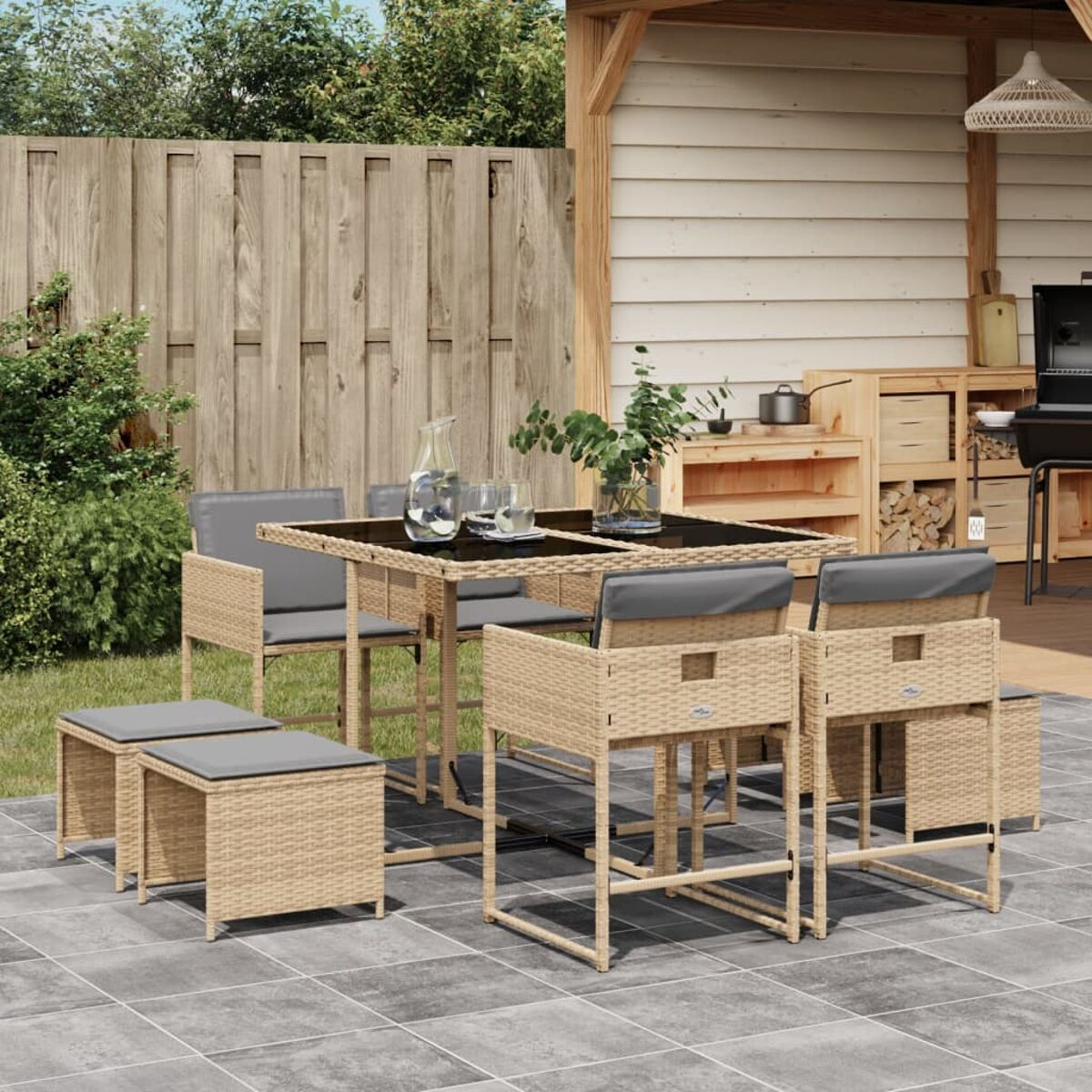 Essgruppe im Freien mit Tisch und Sitzen, neben einer Theke mit Grill.
