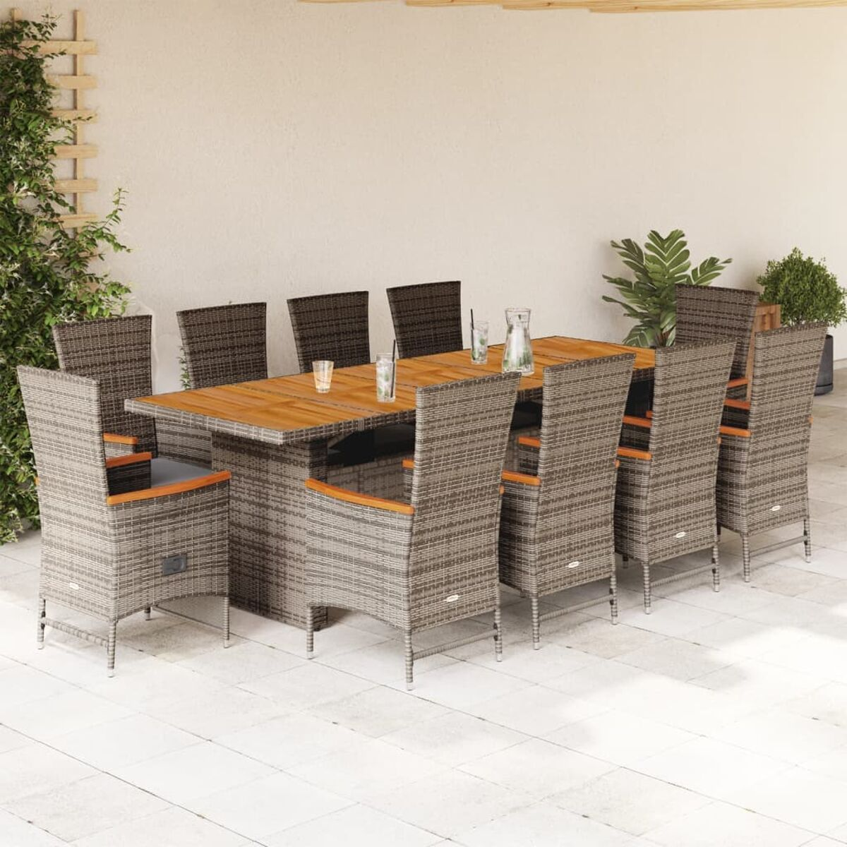 Essgruppe im Freien mit Holztisch und Stühlen. Das Set befindet sich auf einer Terrasse. Pflanzen, Bäume.