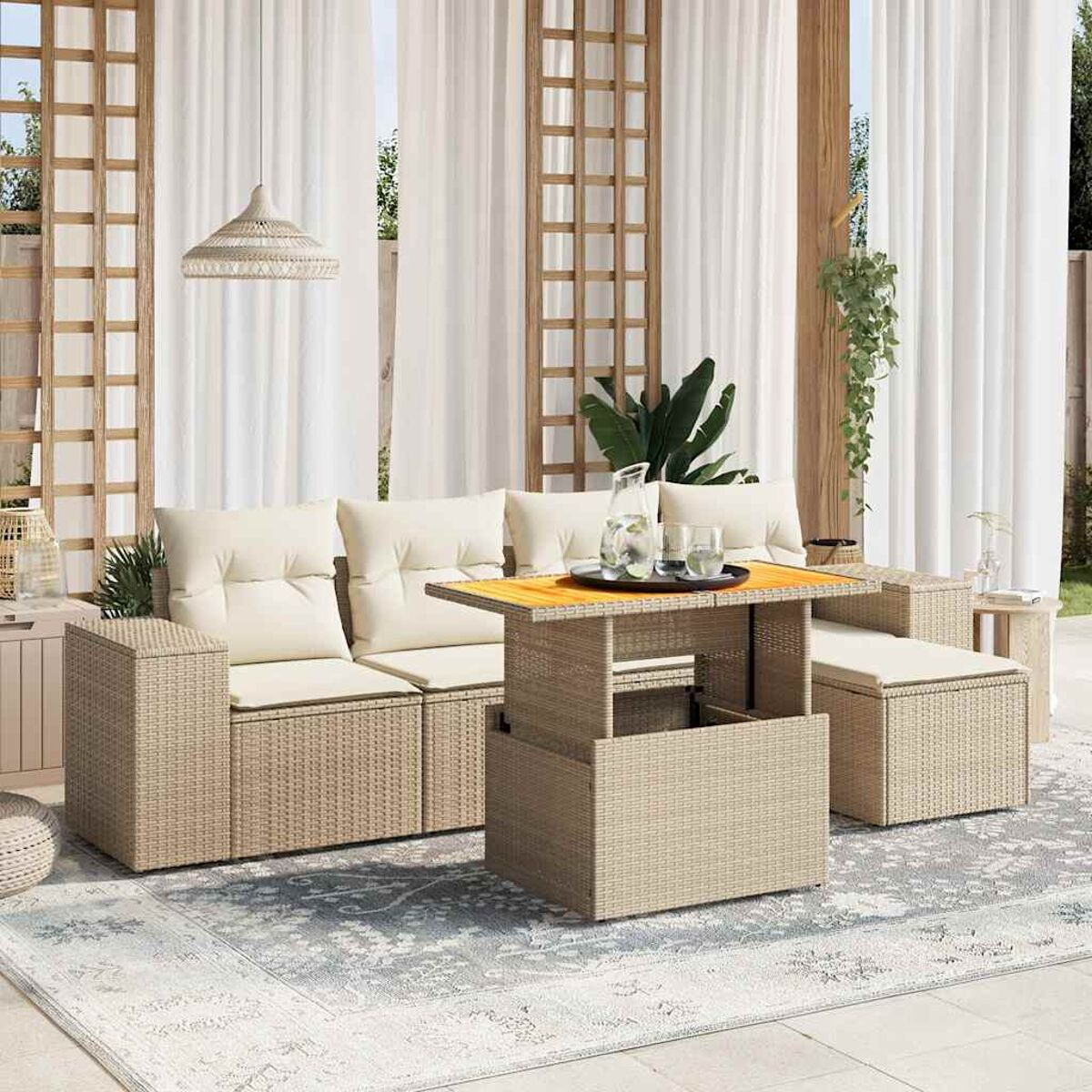 Outdoor-Terrassenset mit Sofa, Tisch und Ottomane. Beige Kissen und Rattanstühle. Vorhänge im Hintergrund.