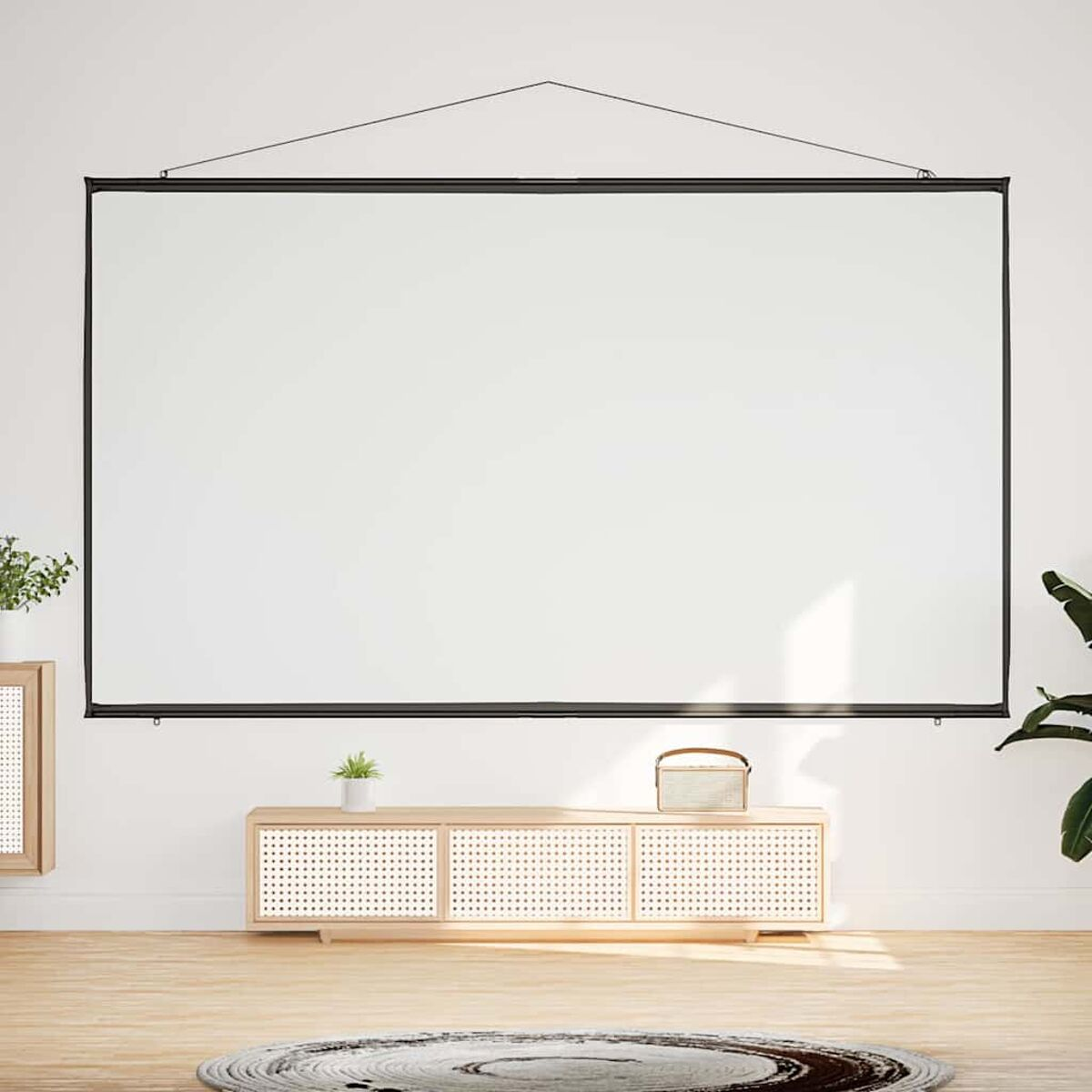 Eine weiße Projektorleinwand an einer weißen Wand mit einem Holzschrank darunter.