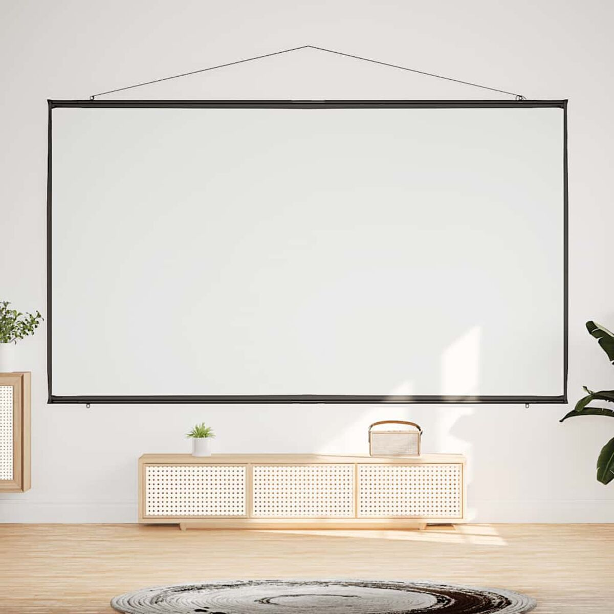 Weißer Projektorbildschirm an einer weißen Wand. Unten befinden sich ein Holzschrank und Pflanzen. Holzboden.