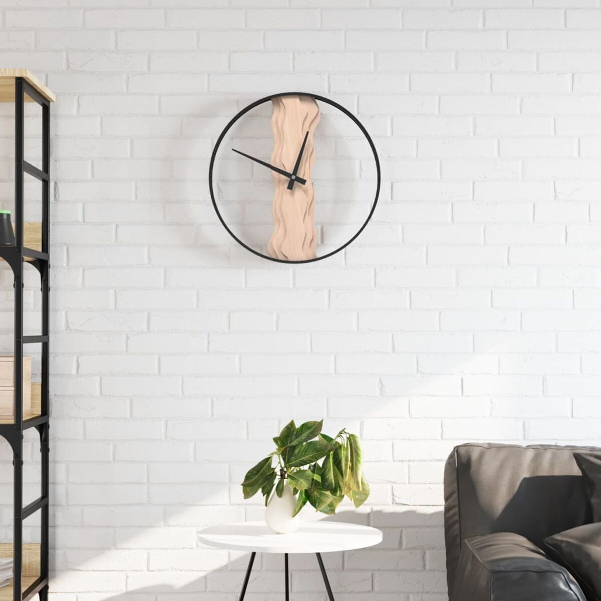 Schwarz gerahmte Uhr mit Holzdesign über einem weißen Tisch mit Pflanze, an weißer Backsteinmauer.