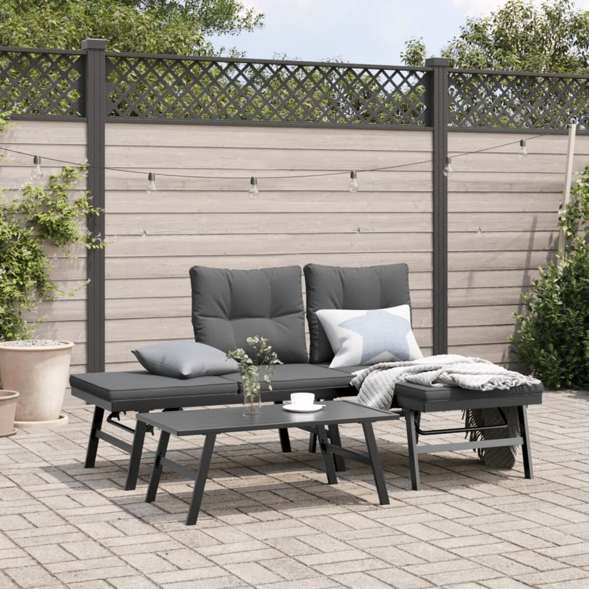 Garnitur für den Außenbereich mit Sofa, zwei Ottomanen und Couchtisch. Ziegelstein-Terrasse.