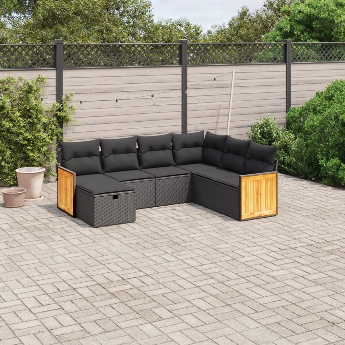 Gartenecksofa mit schwarzen Kissen und Holzakzenten. Backstein-Terrasse.