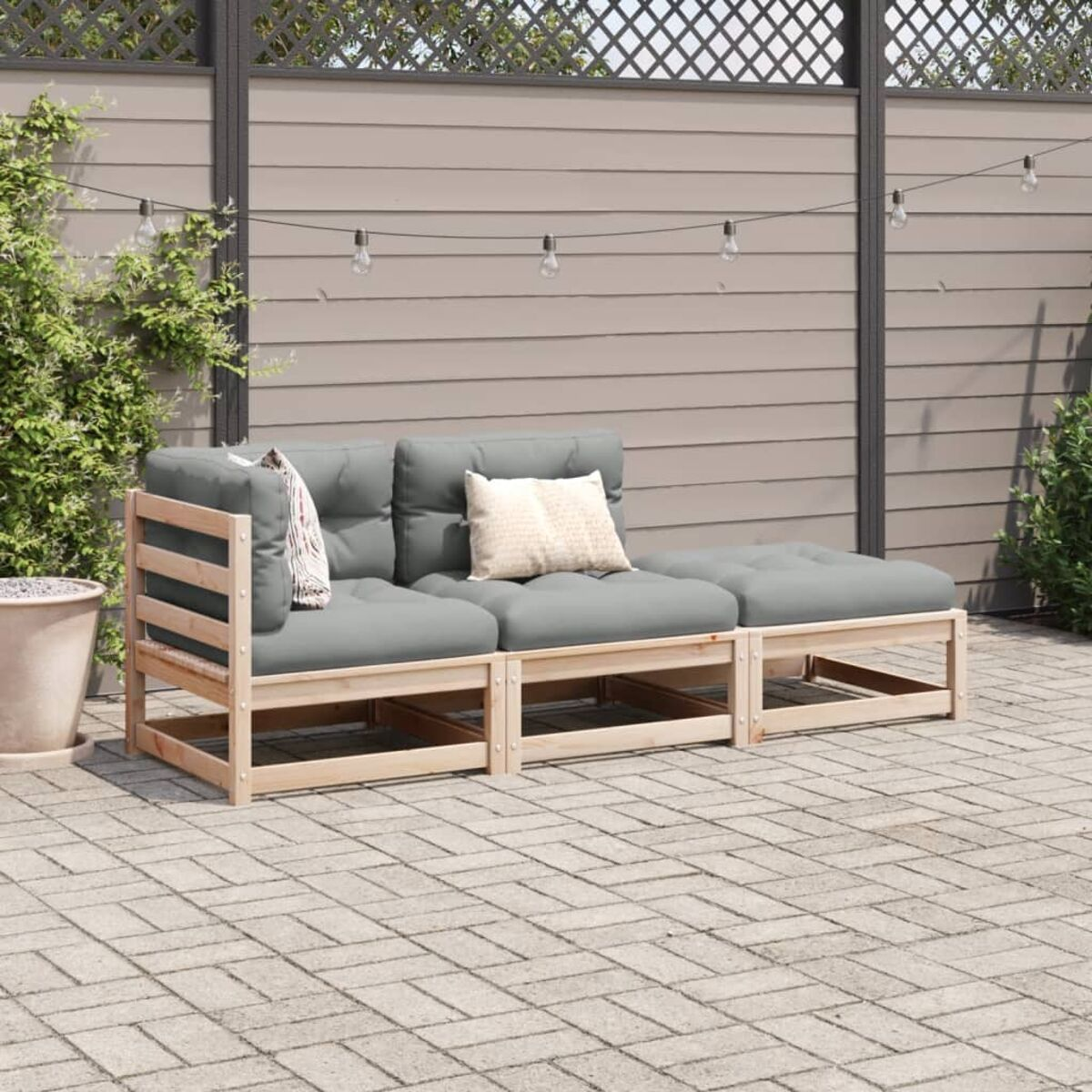 Sitzbereich im Freien mit Holzrahmen-Sofa und Kissen, auf Ziegelpflaster.