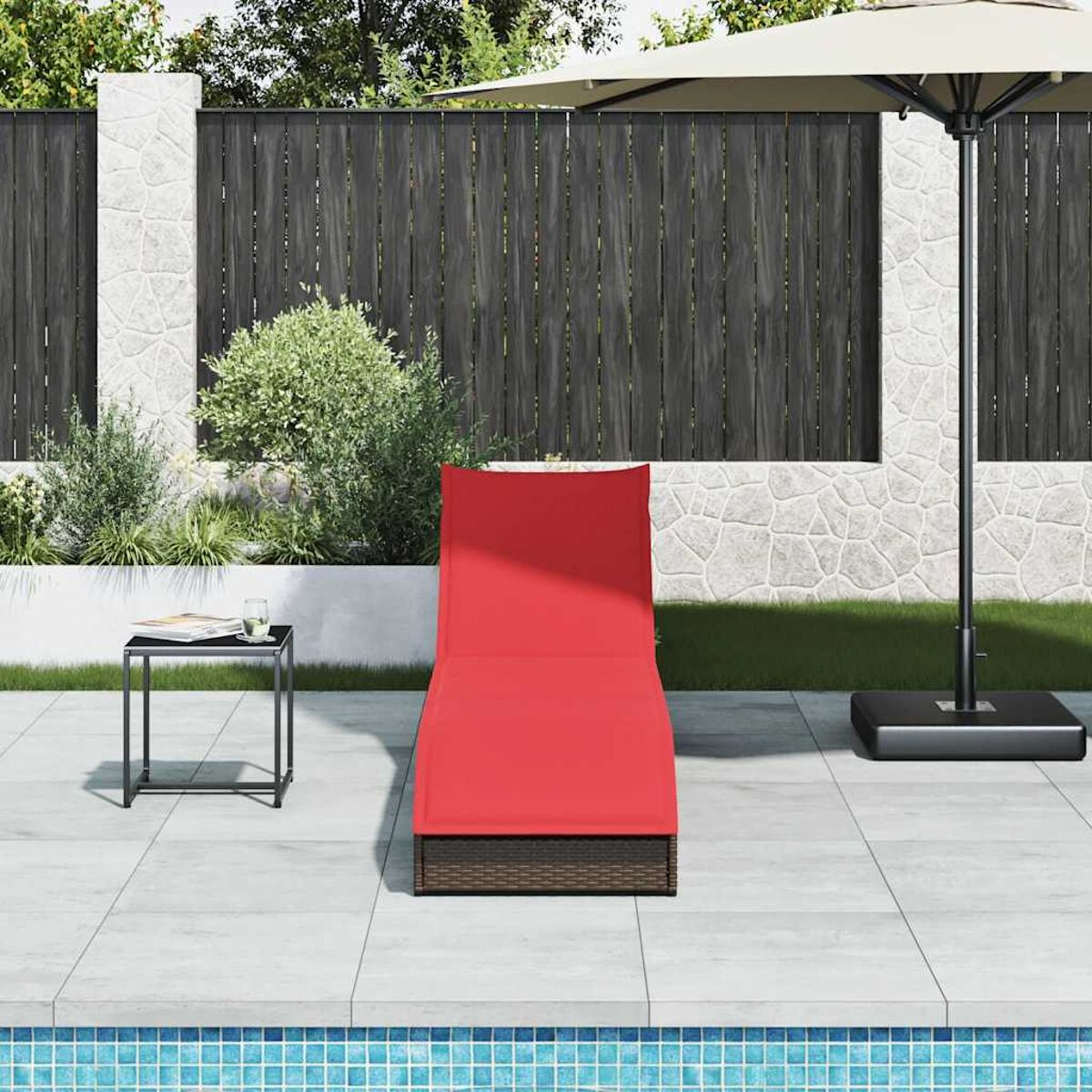 Lettino rosso sul patio, tavolino nero, ombrellone, recinzione e piscina blu.