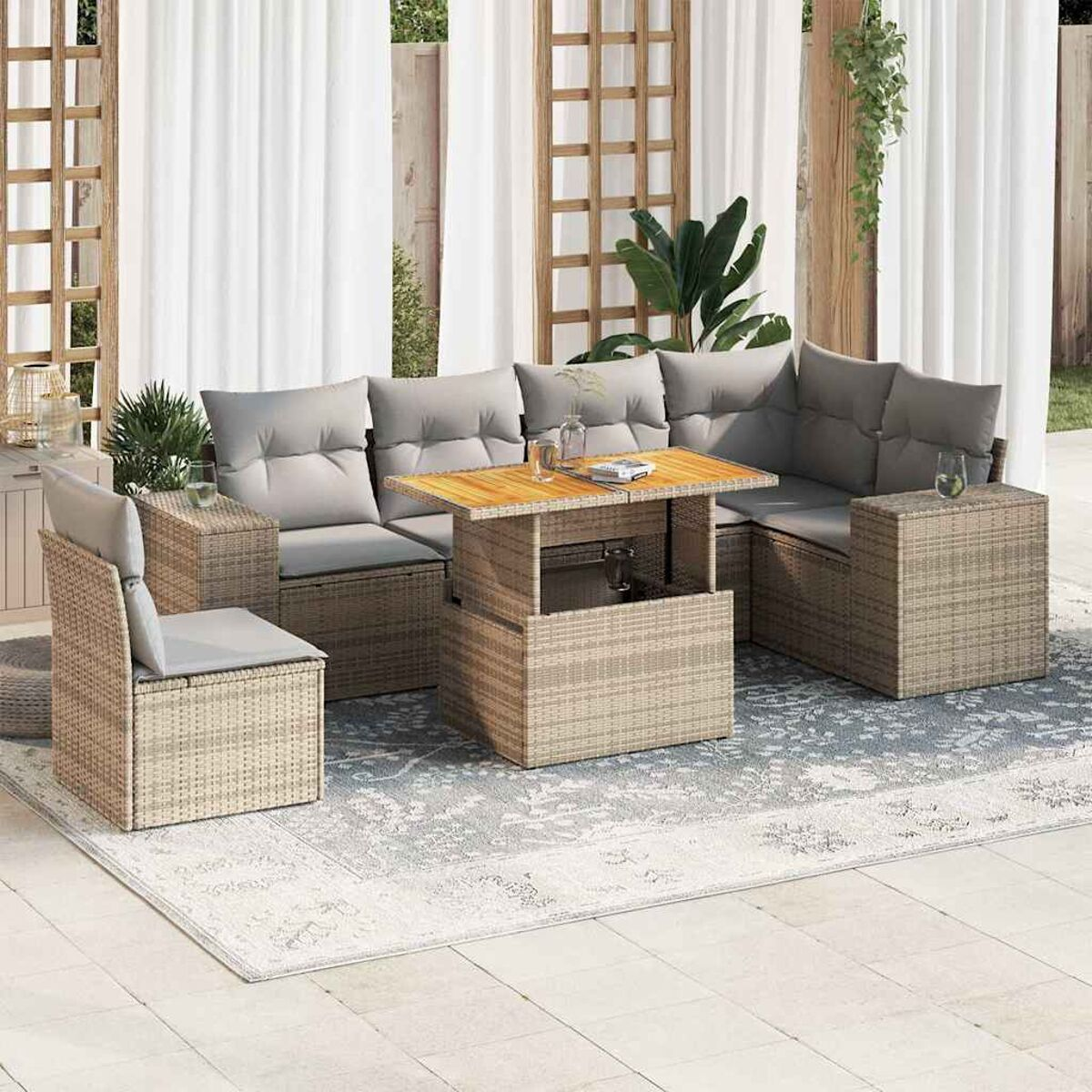 Set da patio esterno, stile vimini, cuscini grigi, tavolo, tende bianche e tappeto.