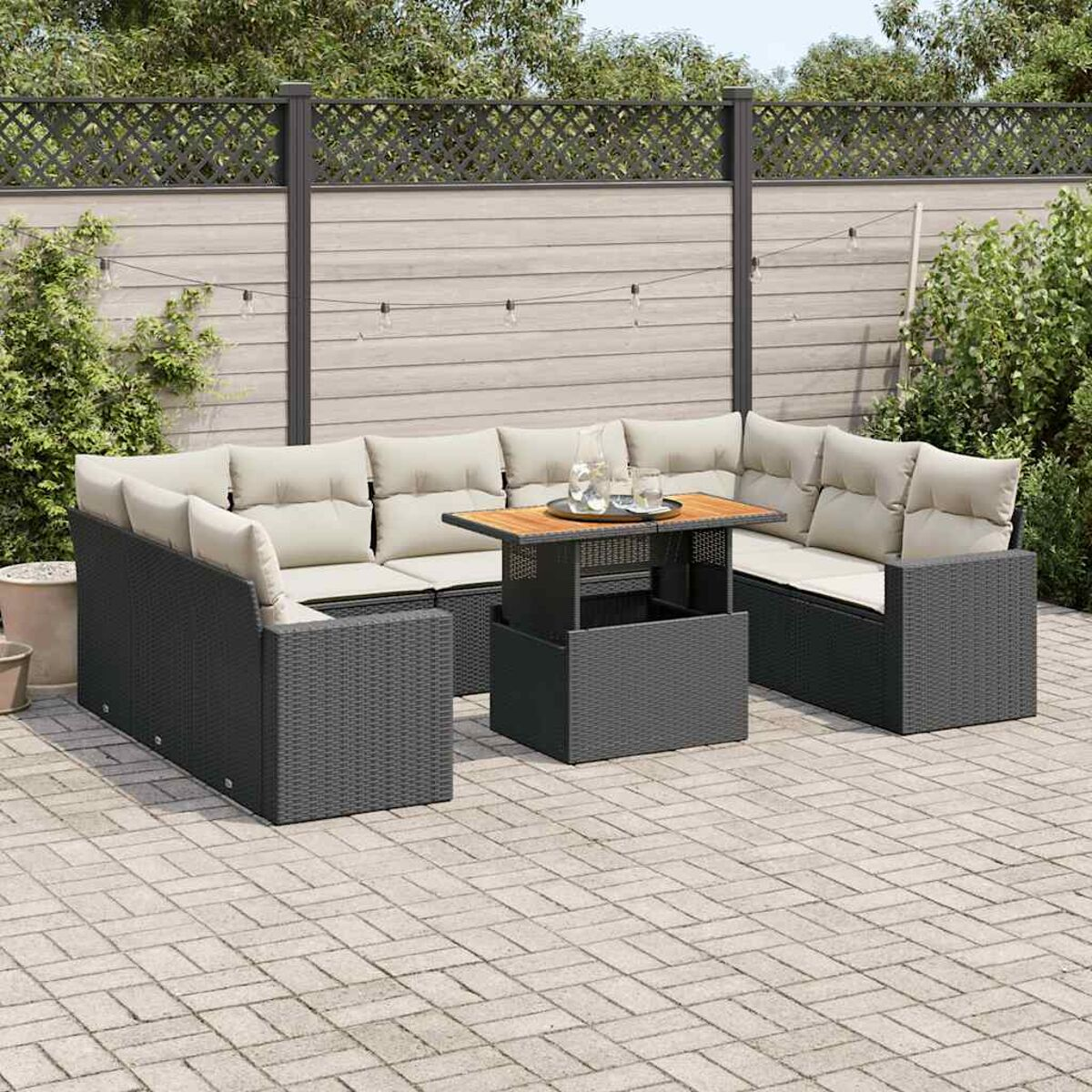 Set divano da esterno in vimini nero con tavolo elevabile su un patio.