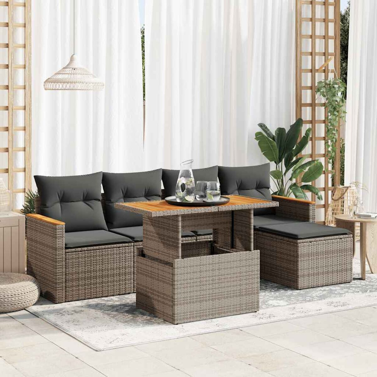 Outdoor-Rattan-Möbelset mit grauen Kissen und Holztisch. Weiße Vorhänge.