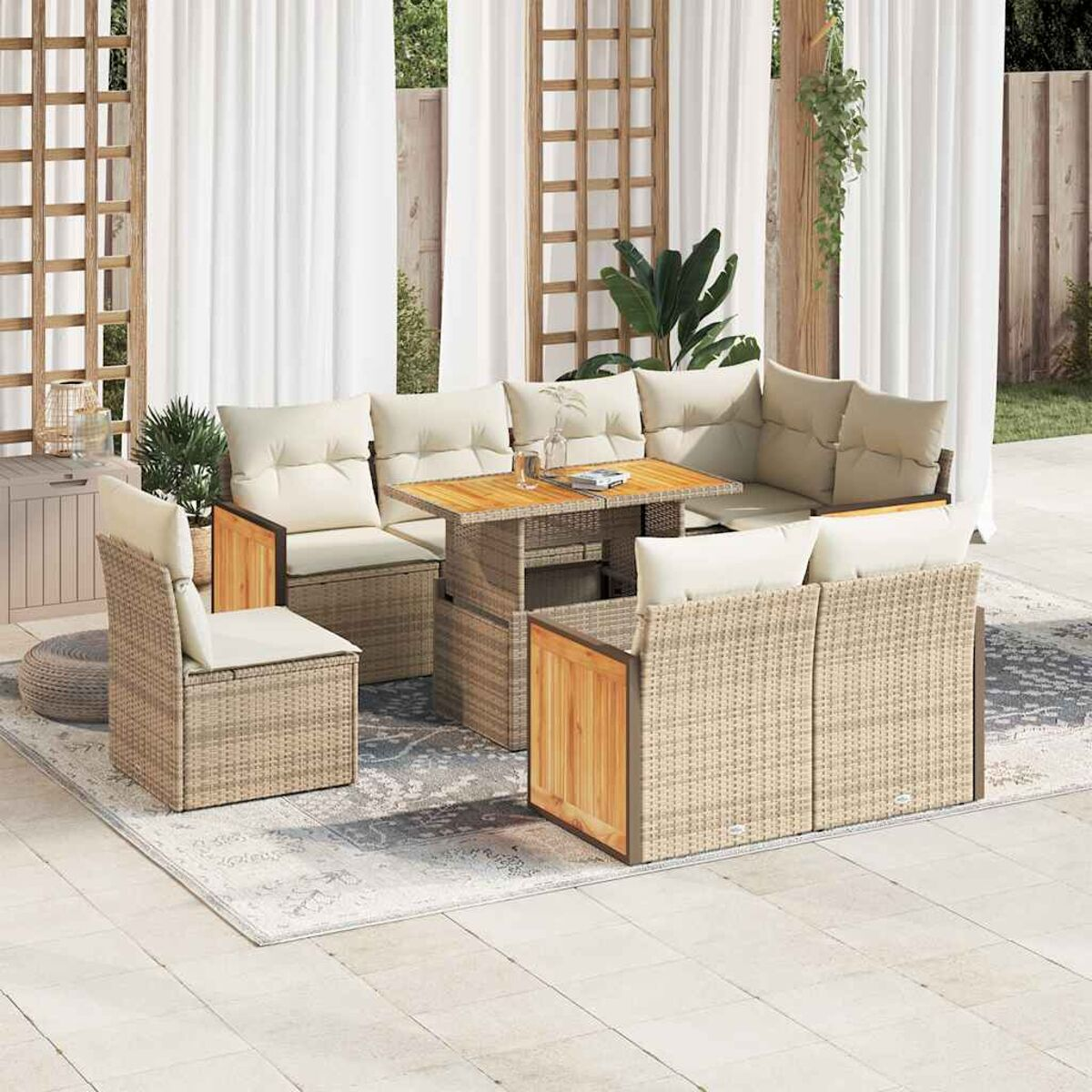 Ein beiges Rattan-Outdoor-Set mit Tisch und Stühlen. Das Set steht auf einem gemusterten Teppich. Der Hintergrund ist weiß.