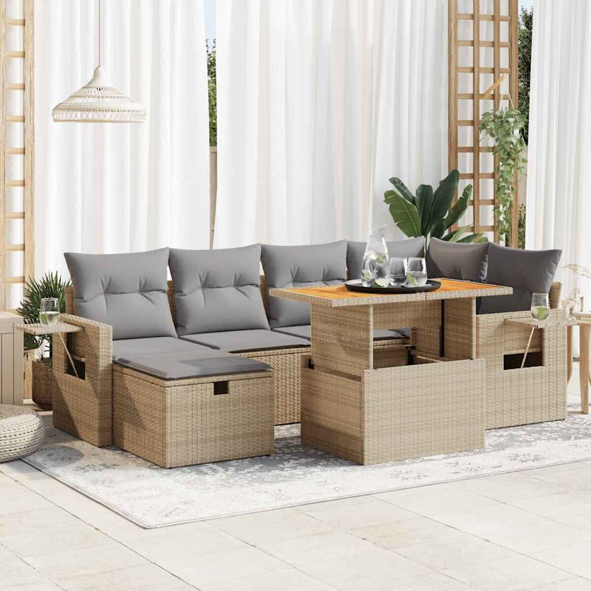 Set di mobili da patio all'aperto. Include divano, tavolo e sedie. Vimini beige con cuscini grigi.