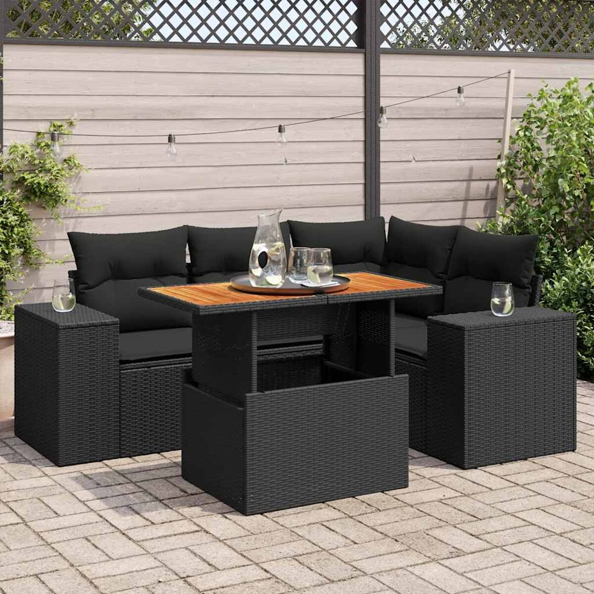 Set di mobili da esterno in vimini nero con tavolo in legno e bevande. Patio.