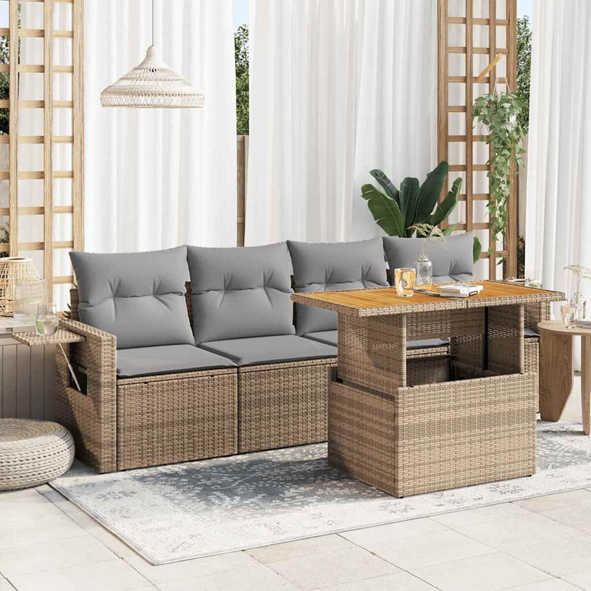 Divano componibile da esterno in rattan con tavolo elevabile su un tappeto.
