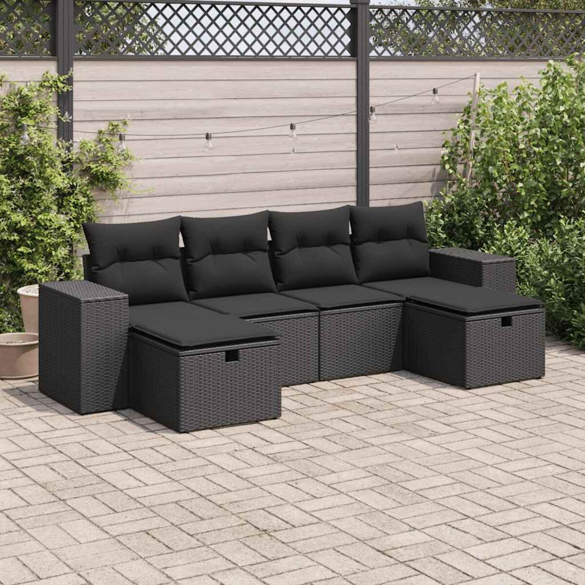 Dunkelgraues Outdoor-Ecksofa mit schwarzen Kissen auf einer Ziegelterrasse.