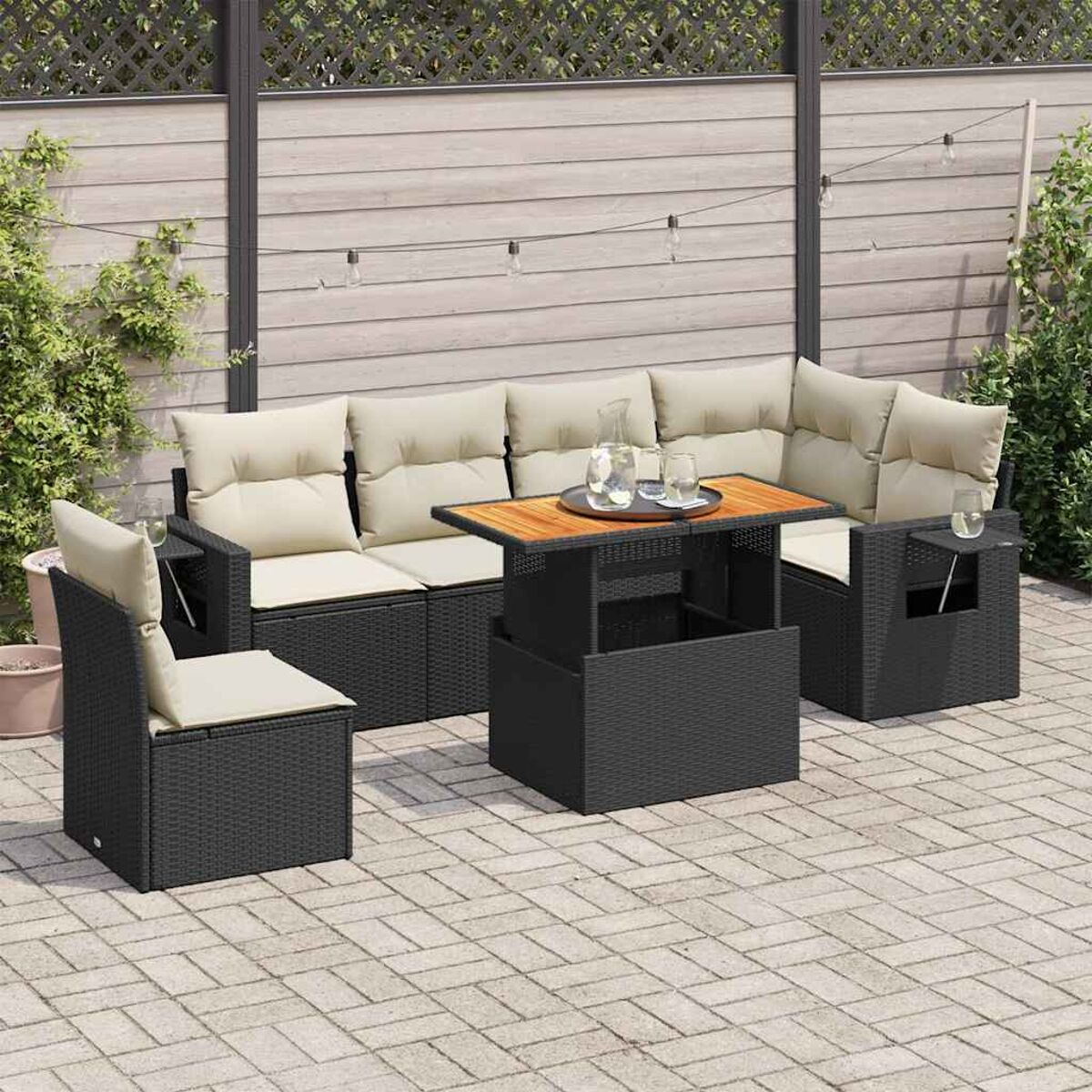 Mobili da patio neri, cuscini beige, tavolo, bicchieri, ambiente esterno e tappeto.