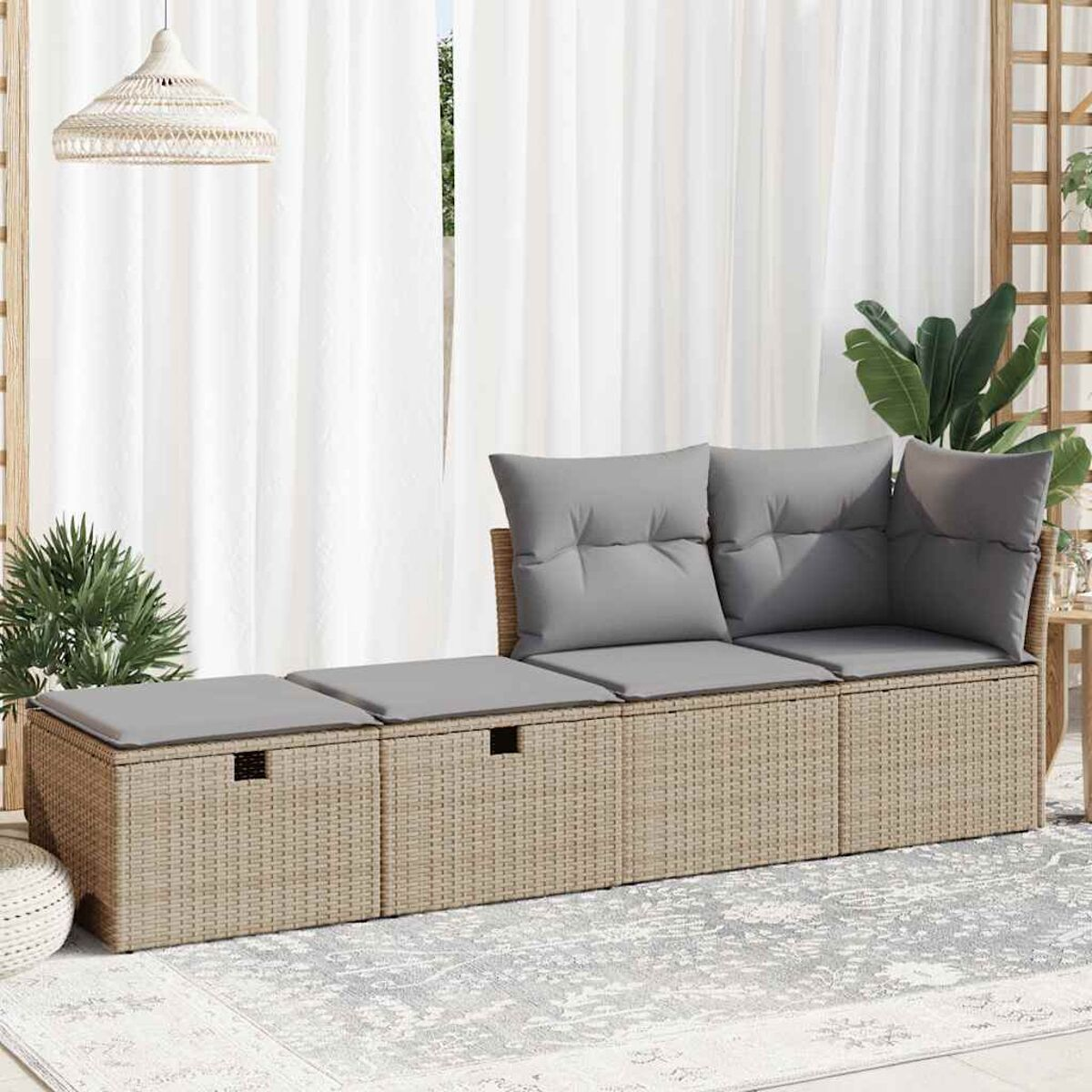 Beiges gewebtes Outdoor-Sofa mit grauen Kissen, auf einem gemusterten Teppich.