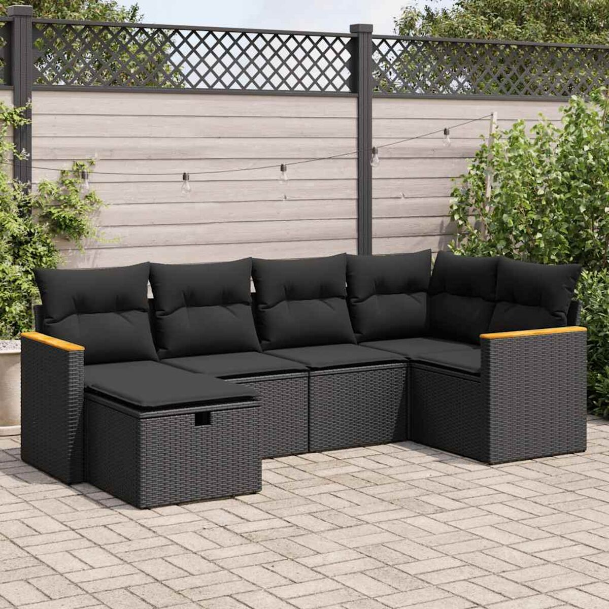 Set di mobili da esterno in rattan nero. Presenta un divano componibile e un tavolino.