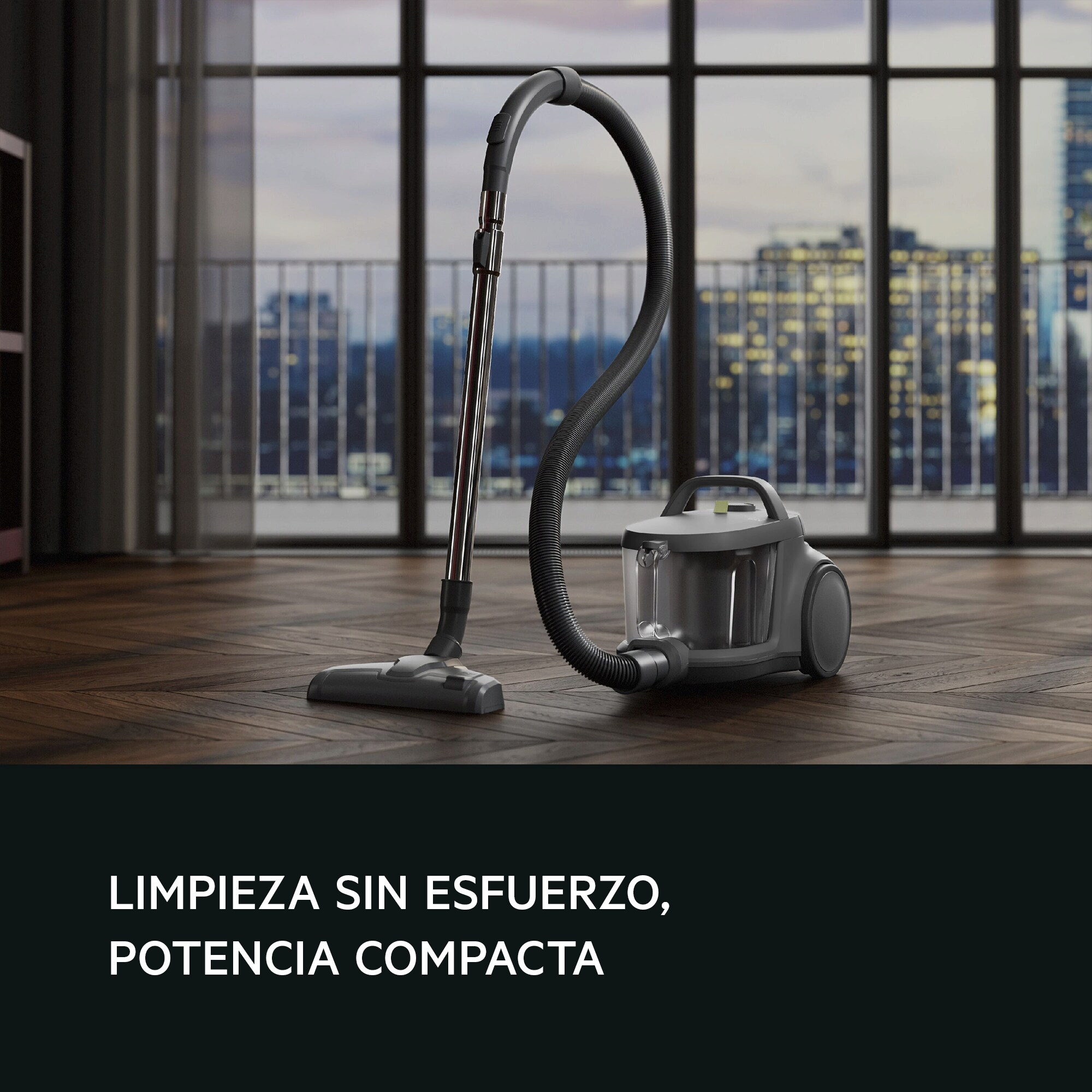 Un aspirapolvere grigio su pavimento in legno con testo: