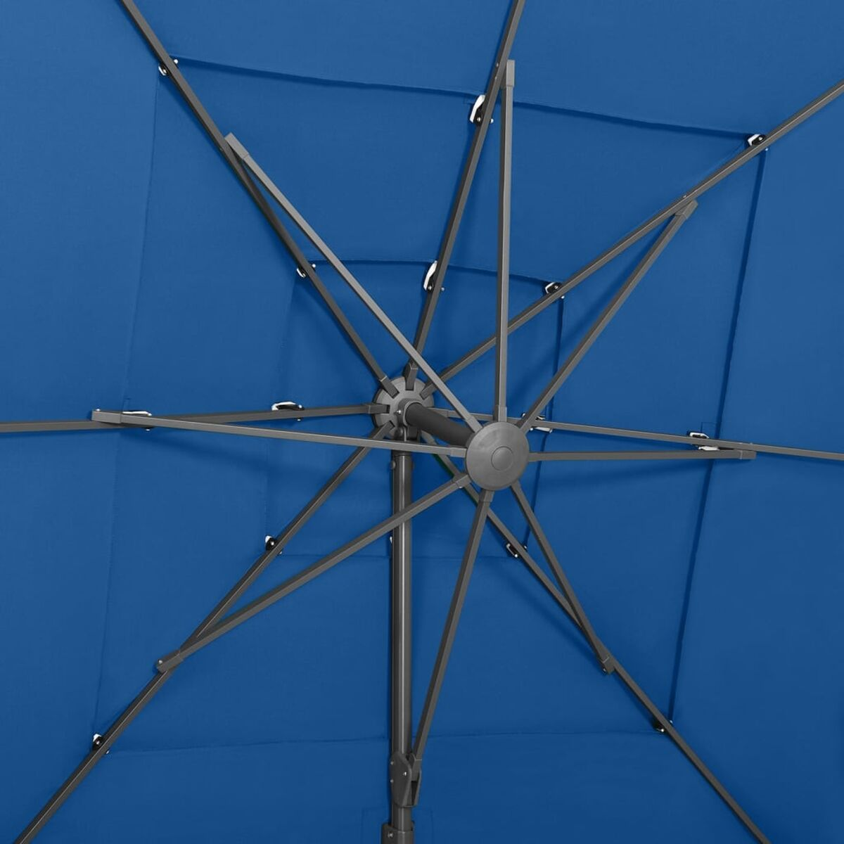 Ansicht von unten des inneren Rahmens eines blauen Schirms. Dunkle Metallrippen strahlen vom Zentrum aus.