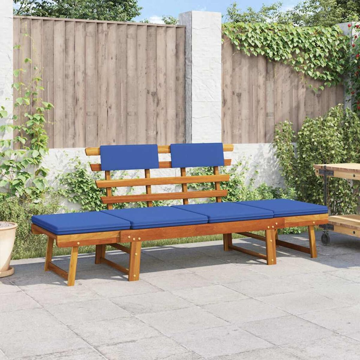 Holzbank mit blauen Kissen. Rückenlehnen auf der Bank. Auf einer Terrasse.