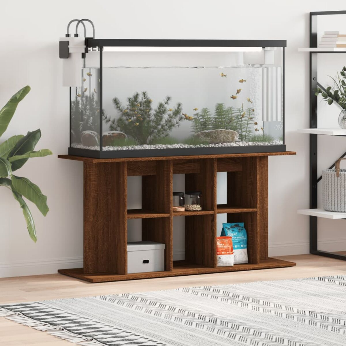Aquarium auf einem Holzständer mit Zubehör. Hintergrund mit weißer Wand und Regalen.