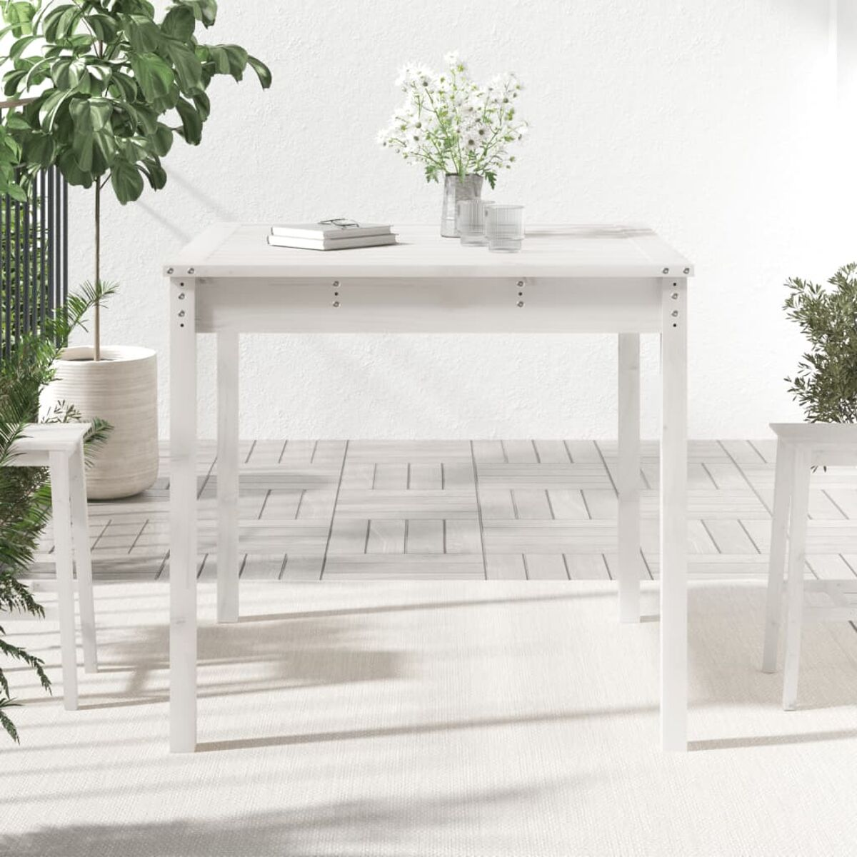 Weißer quadratischer Tisch mit weißen Stühlen. Auf weißem Teppich und Holzboden.