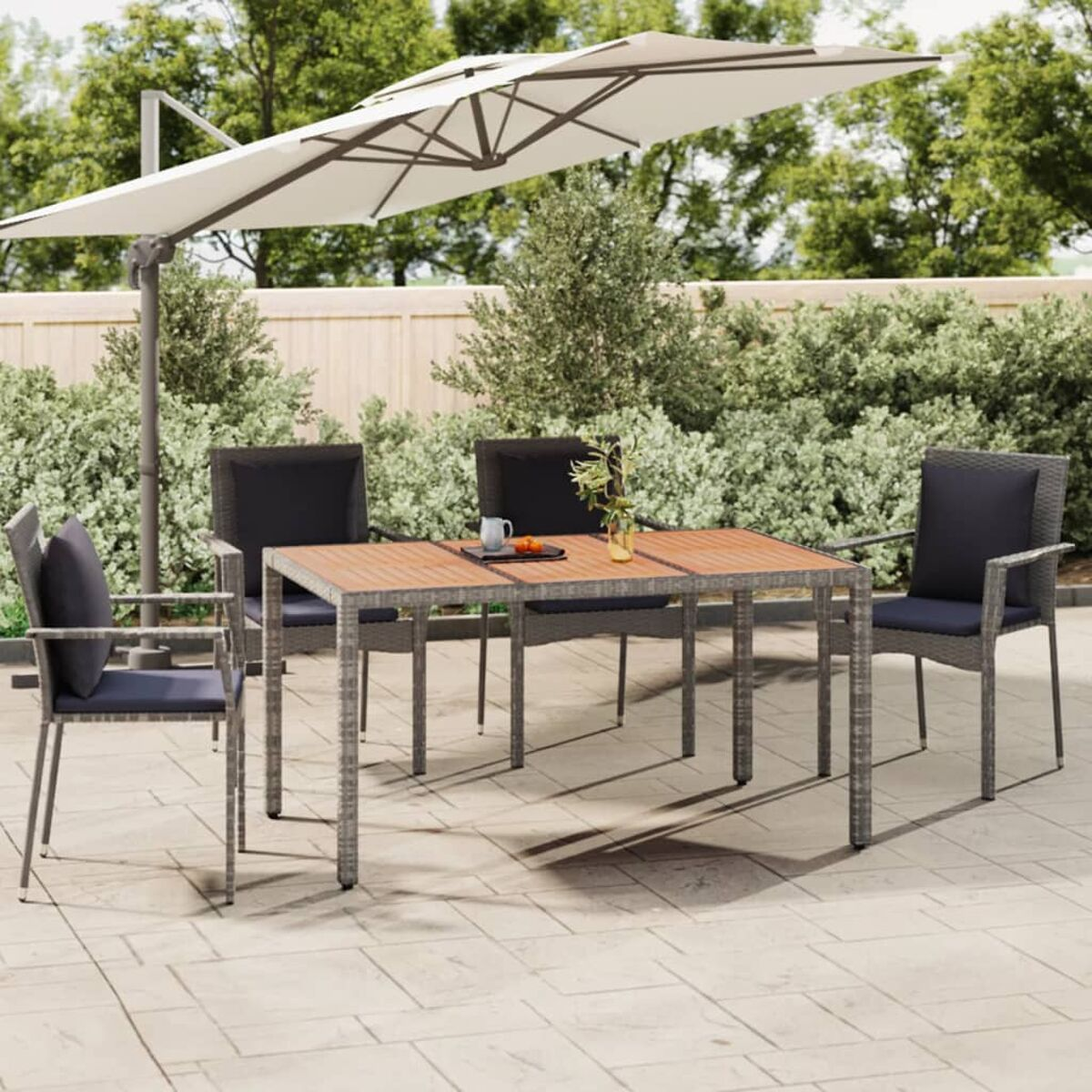 Essgruppe für den Außenbereich mit Tisch, Stühlen und Sonnenschirm.