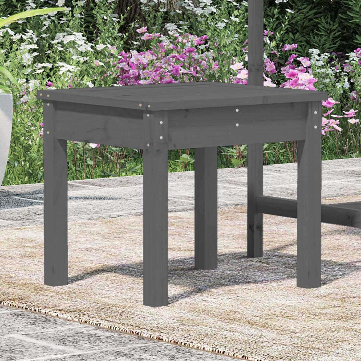 Grauer Holztisch mit quadratischen Beinen. Verschwommener Hintergrund im Freien.