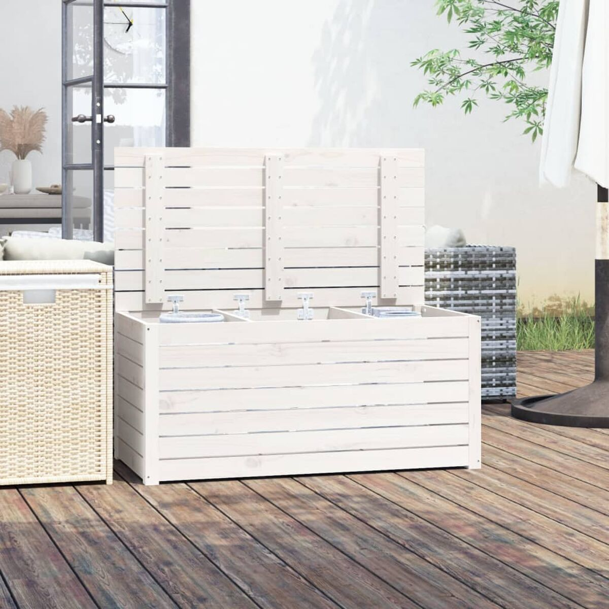 Weiße Holzaufbewahrungsbox mit offenem Deckel, neben einem Weidenkorb auf Holzterrasse.