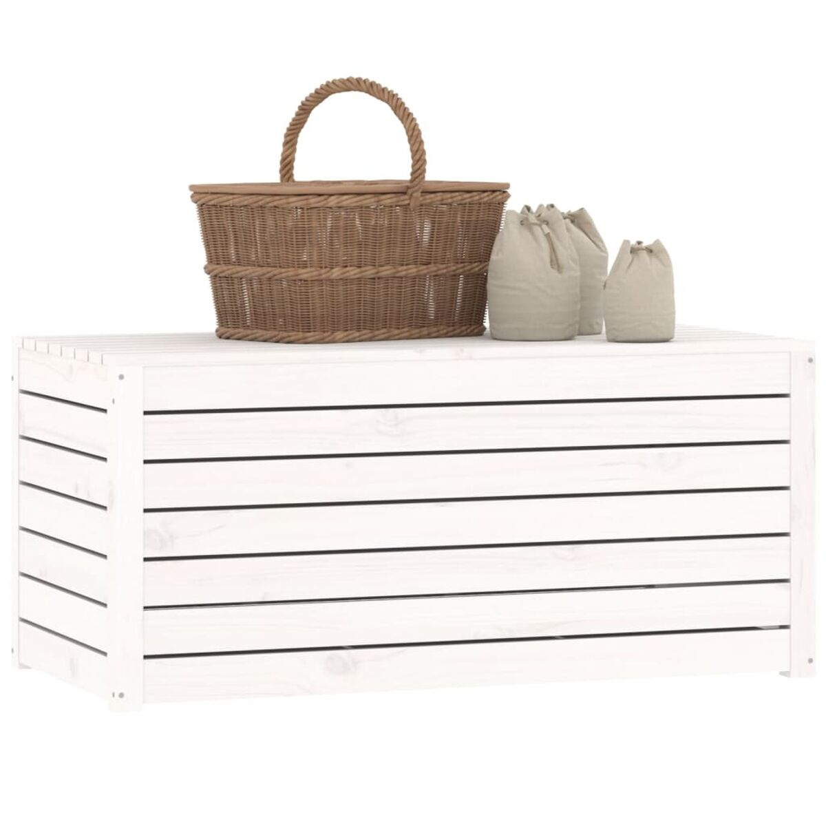 Eine weiße Truhe. Sie hat einen Weidenkorb und zwei beige Taschen oben drauf, vor weißem Hintergrund.