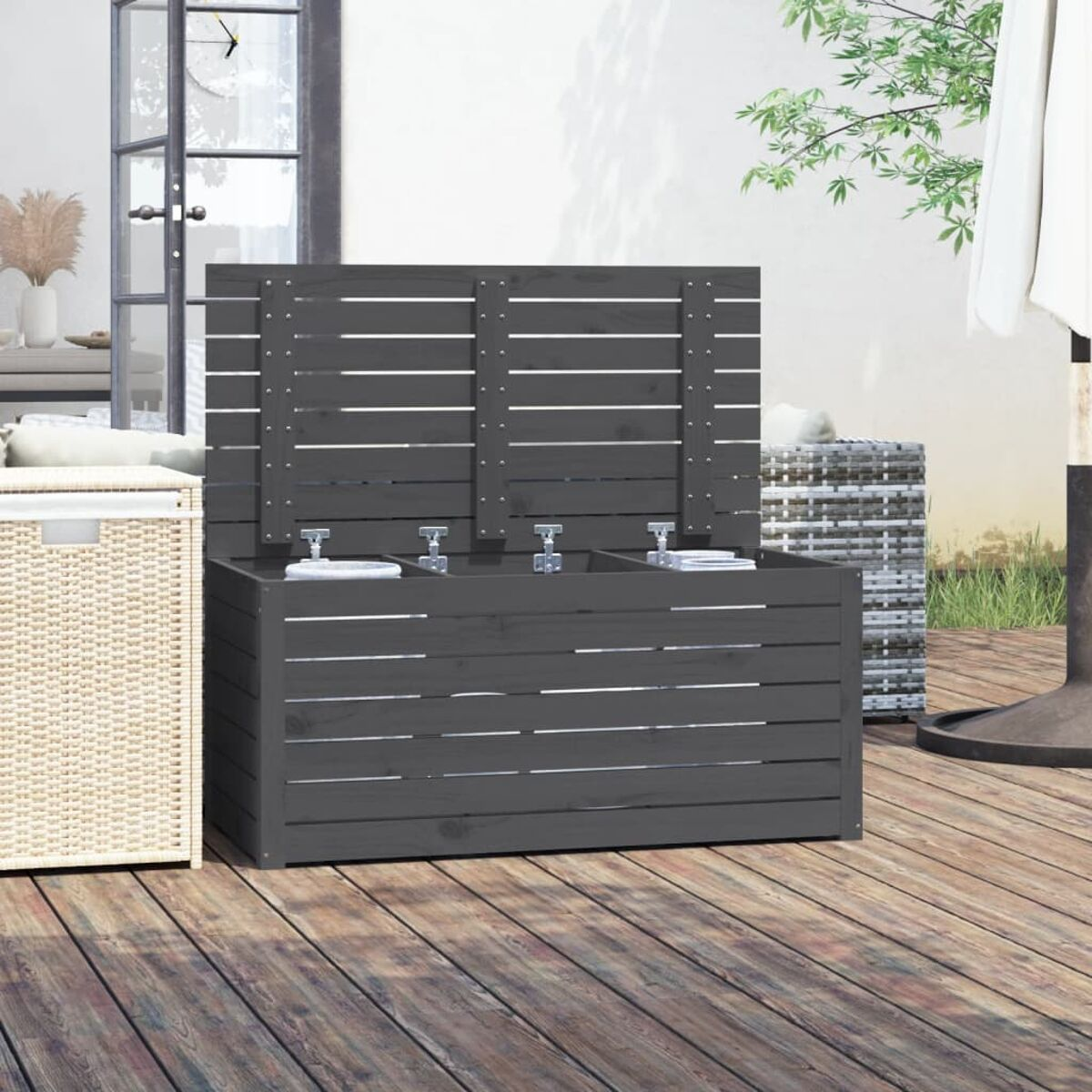 Dunkelgraue Holz-Outdoor-Aufbewahrungsbox mit offenem Deckel und Gegenständen, Holzterrasse.