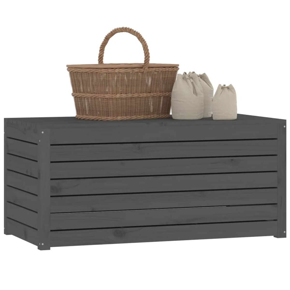 Graue Holz-Outdoor-Truhe, gekrönt mit einem Korb und zwei Segeltuchtaschen. Solides Design.