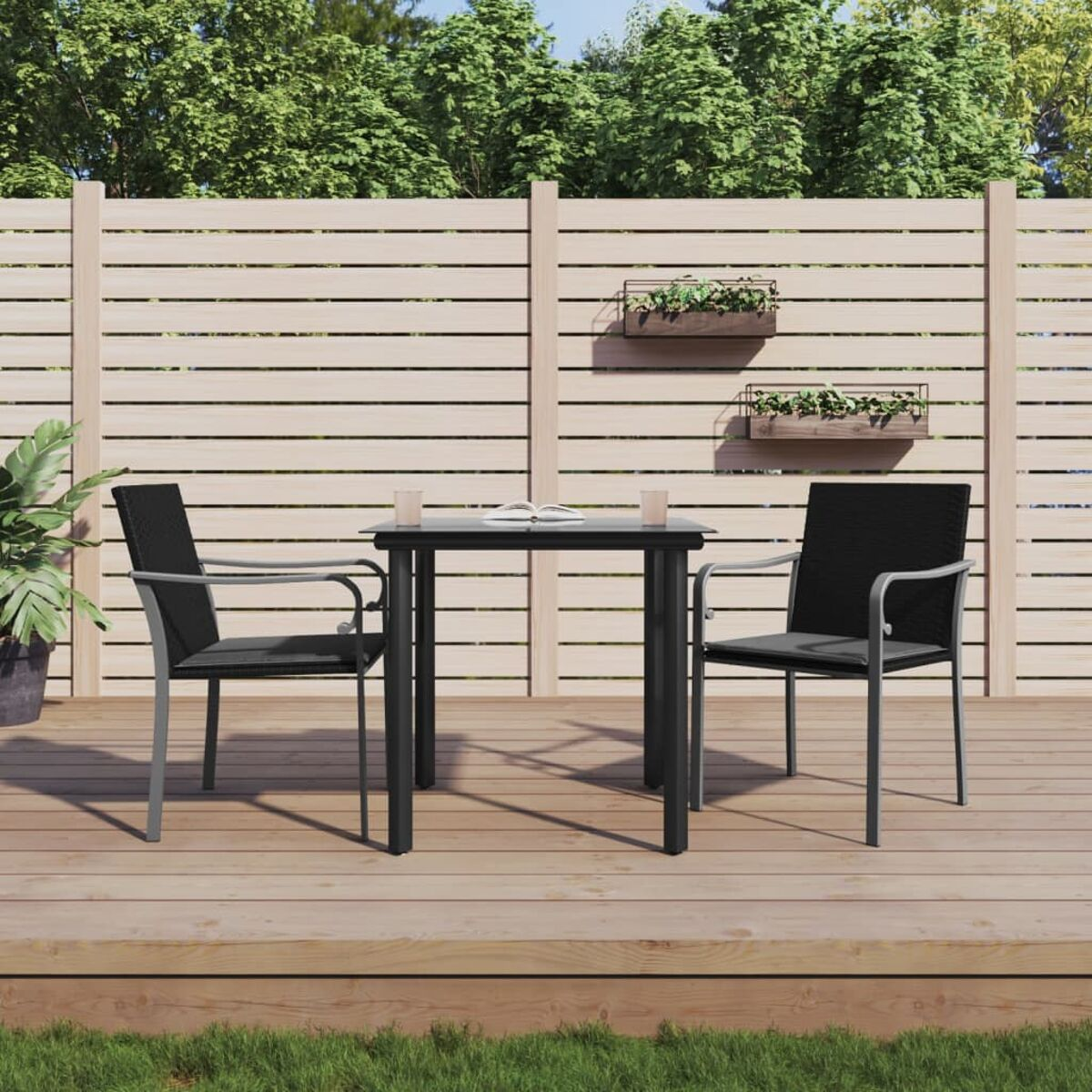 Outdoor-Setting mit schwarzen Stühlen, Tisch, auf Holzterrasse und Zaun im Hintergrund.