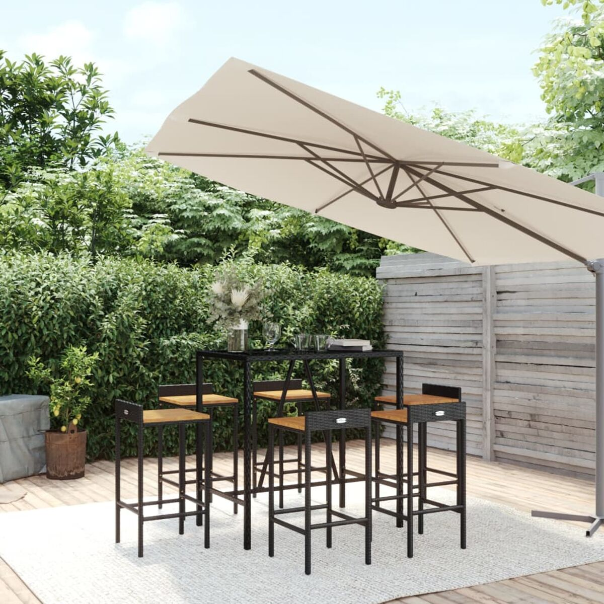 Bar-Set im Freien mit Hockern, Tisch und Sonnenschirm.