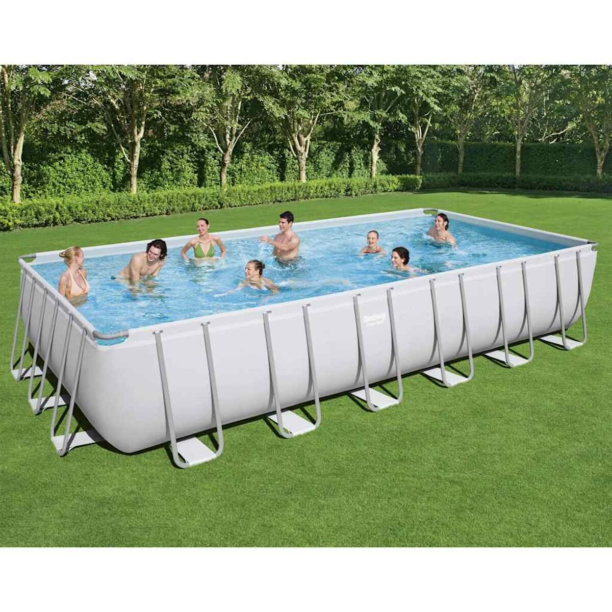 Menschen schwimmen in einem rechteckigen Aufstellpool. Grünes Gras umgibt ihn.