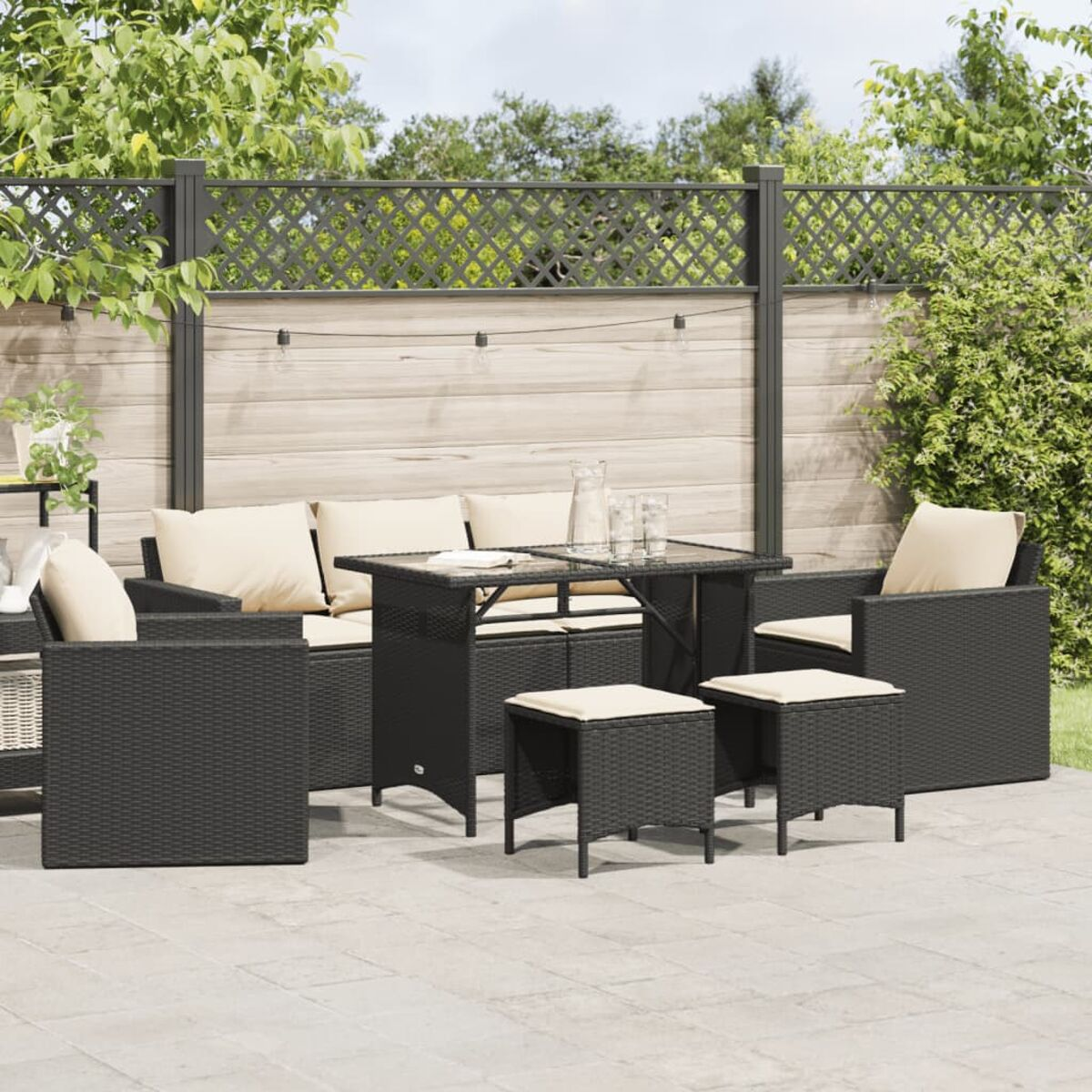 Schwarzes gewebtes Sitzmöbel-Set für den Außenbereich mit Tisch und Kissen.
