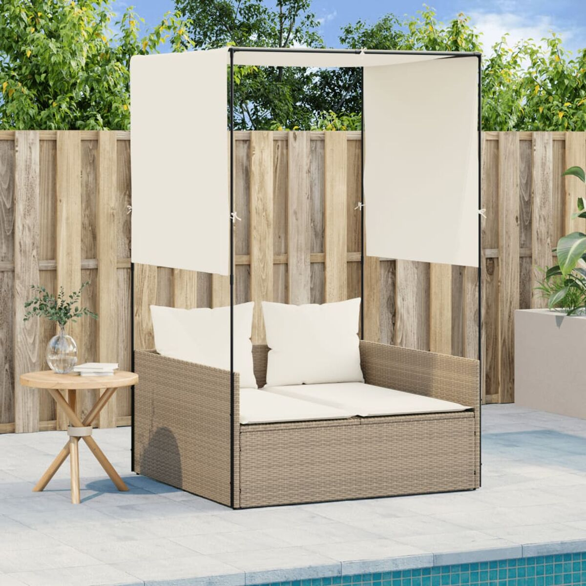 Beige Tagesbett mit Baldachin, weißen Kissen und kleinem Beistelltisch auf einer Terrasse.