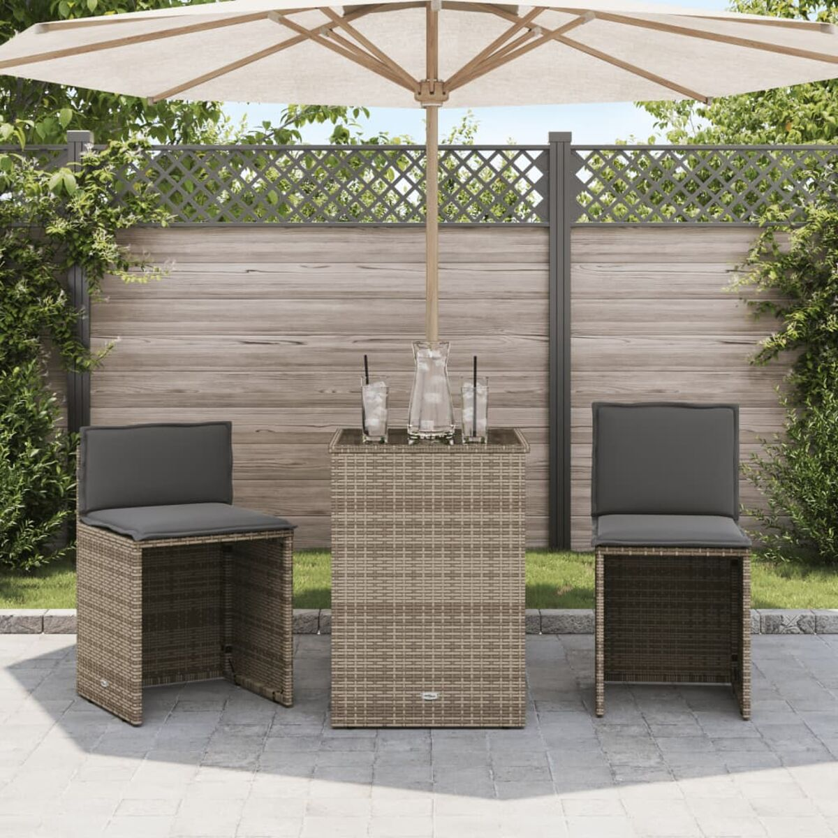 Terrassenmöbel mit Tisch, Sonnenschirm und Stühlen. Graue Kissen. Sonniger Tag.