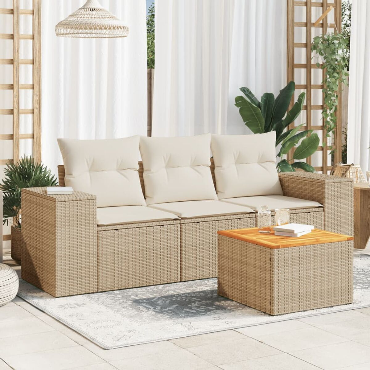 Beiges Rattansofa-Set mit cremefarbenen Kissen, Tisch und Teppich. Pflanzen und eine Hängelampe sind sichtbar.
