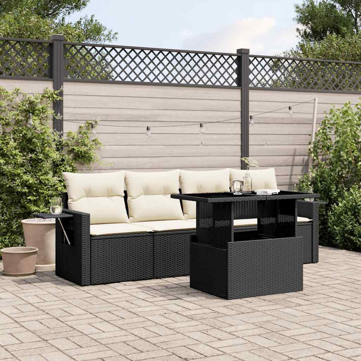 Schwarzes Outdoor-Sofa-Set aus Korbgeflecht mit beigen Kissen und einem Hubtisch.
