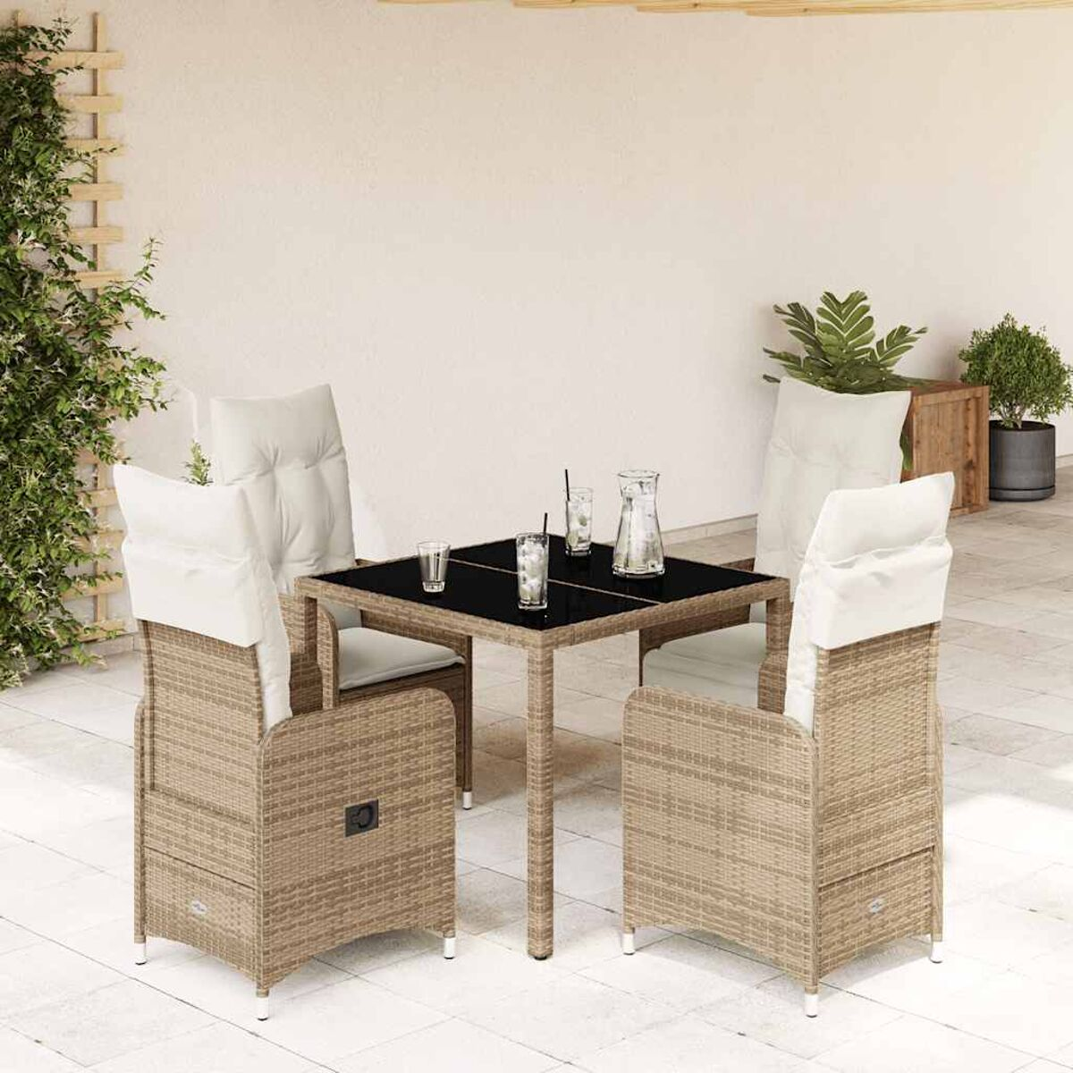 Set da pranzo in rattan da esterno con tavolo in vetro nero e due sedie con cuscini.