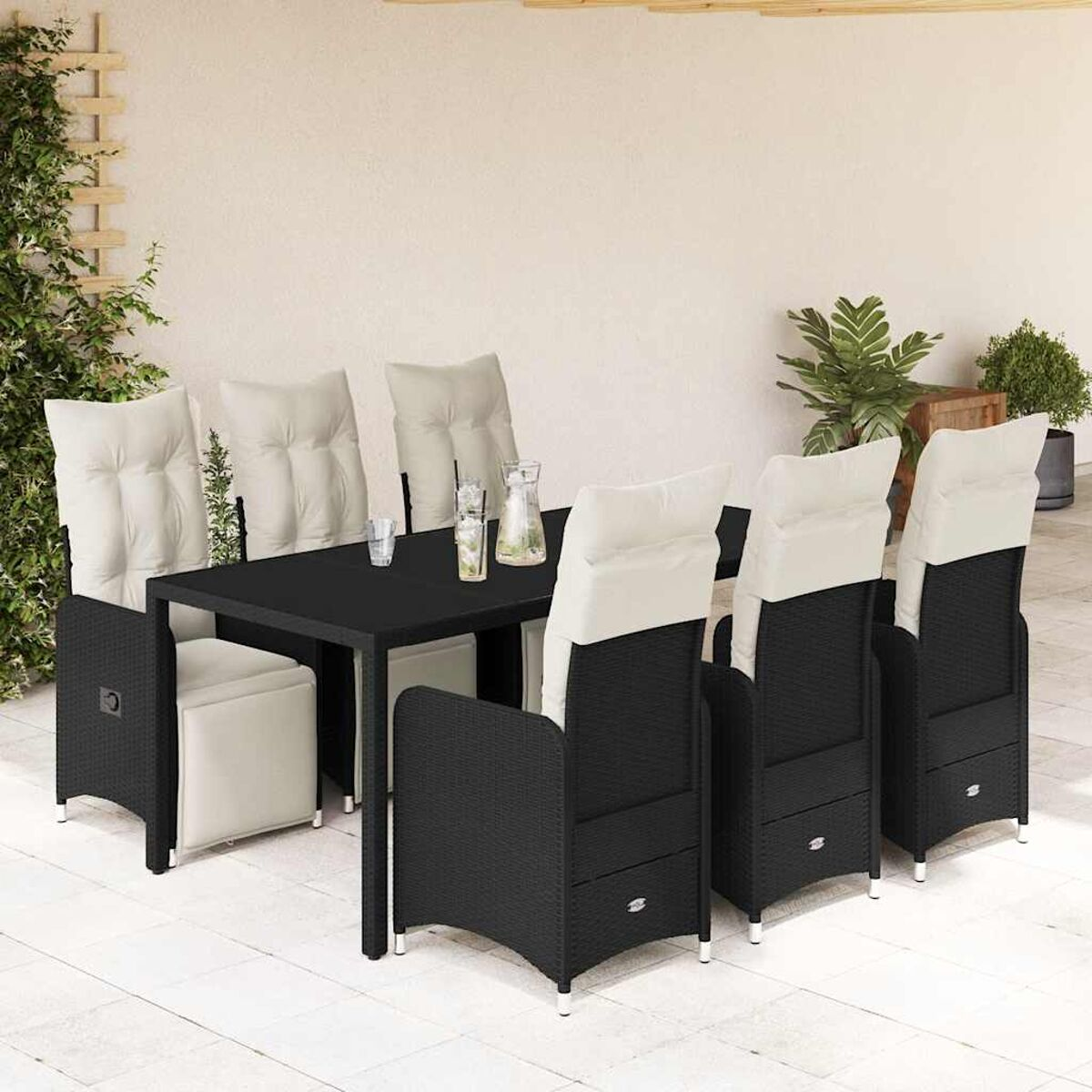Set da pranzo in vimini nero: tavolo con 6 sedie con cuscini bianchi. Patio con parete.