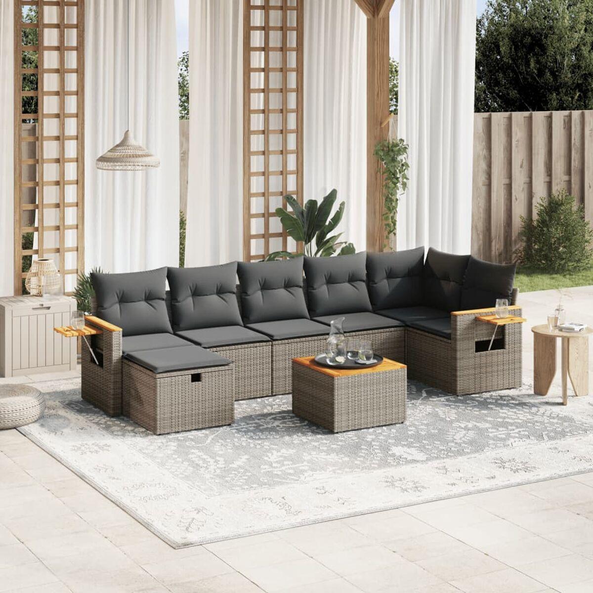 Ecksofa im Freien mit Holztisch und Beistelltischen. Graue Kissen.