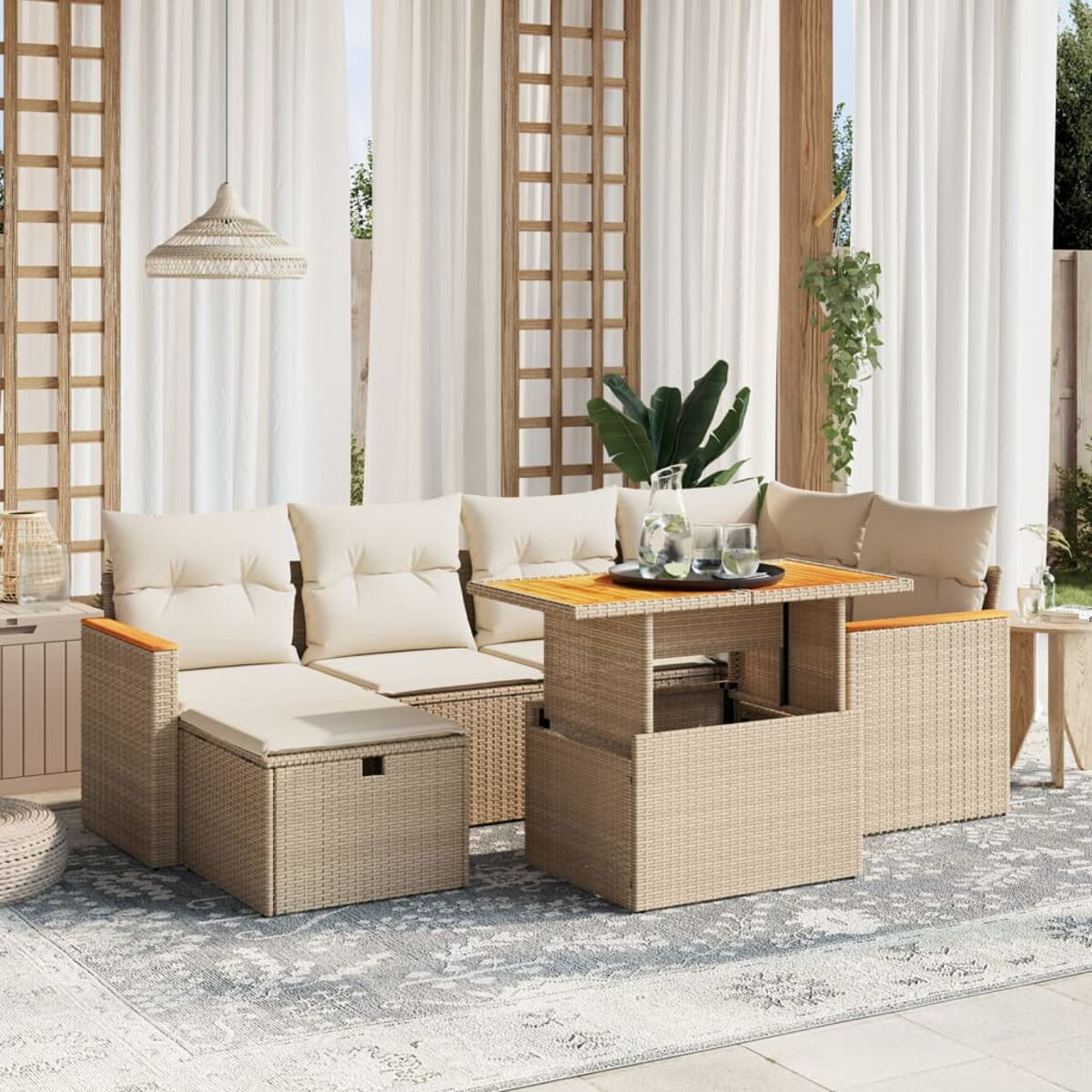 Set di sedute per esterni con cuscini beige, un tavolo sollevabile e un tappeto, con uno sfondo di tenda bianca.