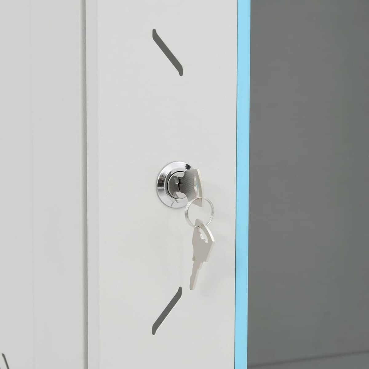 Nahaufnahme einer weißen Schranktür mit einem Schlüssel im Schloss. Zwei Schlüssel an einem Schlüsselring.