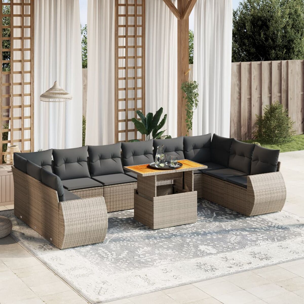 Outdoor-Sofa-Set aus Korbgeflecht mit grauen Kissen und Tisch. Sonniger Tag.